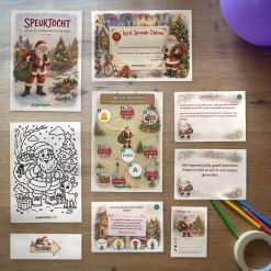Alle onderdelen van de kerst Speurtocht op tafel: voorblad, diploma, oplossingskaart, kleurplaat, opdrachtkaarten, speluitleg, uitnodigingen en pijlen
